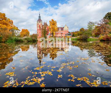 Blick auf Schloss Muskau, das im Herbst im Teich reflektiert wird, Bad Muskau, Sachsen, Deutschland Stockfoto