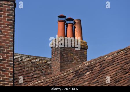 In einem ländlichen Dorf in Hampshire, England, befindet sich ein alter Ziegelkamin mit Keramiktopf auf der Oberseite. Stockfoto