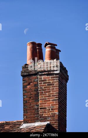 In einem ländlichen Dorf in Hampshire, England, befindet sich ein alter Ziegelkamin mit Keramiktopf auf der Oberseite. Stockfoto