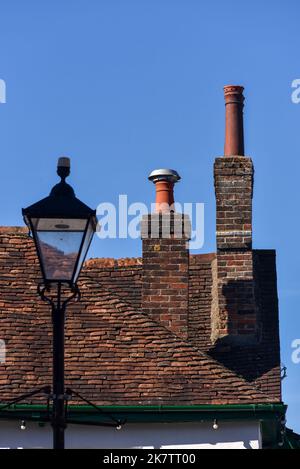 In einem ländlichen Dorf in Hampshire, England, befindet sich ein alter Ziegelkamin mit Keramiktopf auf der Oberseite. Stockfoto