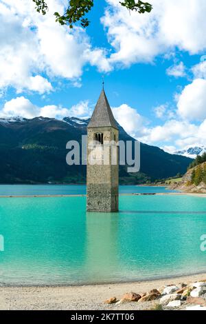 Der übrig gebliebene Kirchturm des alten Graun/Graun-Dorfes liegt im neuen Wasserreservoir im Vinschgau Italien Stockfoto
