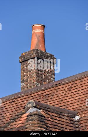 In einem ländlichen Dorf in Hampshire, England, befindet sich ein alter Ziegelkamin mit Keramiktopf auf der Oberseite. Stockfoto