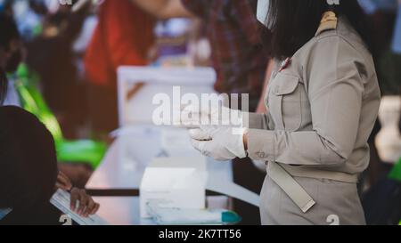 Uniform Teachers führen in Schulen mit Gesichtsmast Tests durch, bei denen Schüler auf COVID-19-Prävention abgestellt werden Stockfoto