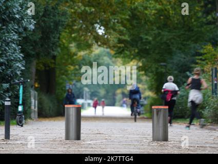 PRODUKTION - 17. Oktober 2022, Hamburg: Passanten gehen und fahren mit dem Fahrrad an einer Polleranlage im Stadtpark vorbei. Im Stadtpark wurde eine einfache Barriere durch das Pollersystem ersetzt. Seitdem ist es seit mehr als vier Jahren außer Betrieb und kostet rund 35.000 Euro für Reparatur und Wartung. Die Ausgabe 50. des Black Book of the Taxpayers' Association wird diesen Mittwoch veröffentlicht. Mit den aktuellen Fällen hat Hamburg seit 1973 182 Einträge. Foto: Marcus Brandt/dpa Stockfoto