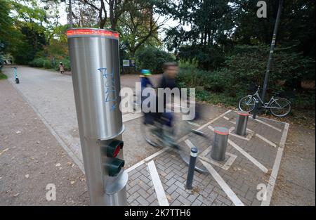 PRODUKTION - 17. Oktober 2022, Hamburg: Passanten fahren im Stadtpark an einem Pollersystem vorbei. Im Stadtpark wurde eine einfache Barriere durch das Pollersystem ersetzt. Seitdem ist es seit mehr als vier Jahren außer Betrieb und kostet rund 35.000 Euro für Reparatur und Wartung. Die Ausgabe 50. des Black Book of the Taxpayers' Association wird diesen Mittwoch veröffentlicht. Mit den aktuellen Fällen hat Hamburg seit 1973 182 Einträge. Foto: Marcus Brandt/dpa Stockfoto