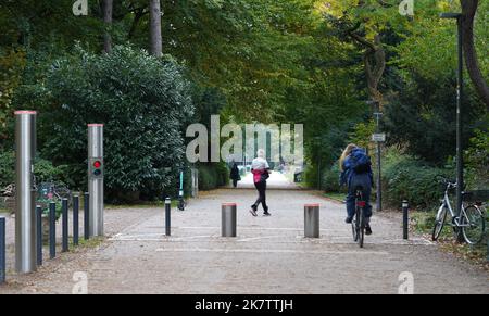 PRODUKTION - 17. Oktober 2022, Hamburg: Passanten gehen und fahren mit dem Fahrrad an einer Polleranlage im Stadtpark vorbei. Im Stadtpark wurde eine einfache Barriere durch das Pollersystem ersetzt. Seitdem ist es seit mehr als vier Jahren außer Betrieb und kostet rund 35.000 Euro für Reparatur und Wartung. Die Ausgabe 50. des Black Book of the Taxpayers' Association wird diesen Mittwoch veröffentlicht. Mit den aktuellen Fällen hat Hamburg seit 1973 182 Einträge. Foto: Marcus Brandt/dpa Stockfoto