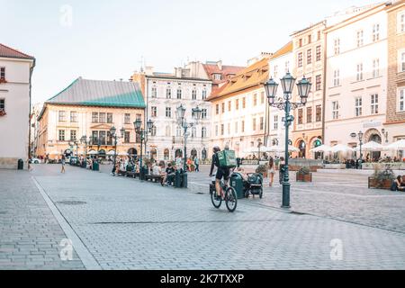 Krakau, Polen - 25. August 2022: Ein nicht identifizierter Uber-Fahrradkurier auf der Straße in Krakau, Polen. Lieferung von Lebensmitteln, Produkten Stockfoto