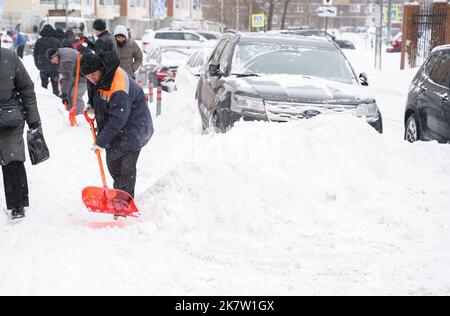 Russland Moskau 13.02.2021 Straßenreiniger, Männer reinigen Schnee von der Straße, Bürgersteig mit großen Schaufeln. Stadt Winter Wetter Zusammenbruch, Schneefall, Schneeverwehungen. Ca Stockfoto