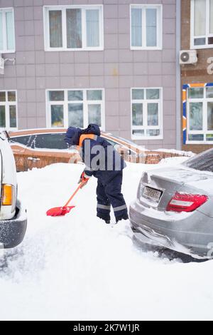 Russland Moskau 13.02.2021 Straßenreiniger, Männer reinigen Schnee von der Straße, Bürgersteig mit großen Schaufeln. Stadt Winter Wetter Zusammenbruch, Schneefall, Schneeverwehungen. Ca Stockfoto