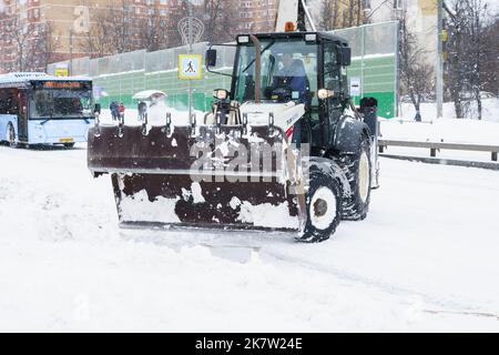 Russland Moskau 13.02.2021 Traktor, Schneeräumgeräte. Straßenreinigung Schnee von der Straße, Bürgersteig. Stadt Winter Zusammenbruch, Schneefall, Schneeverwehungen. Schwere s Stockfoto