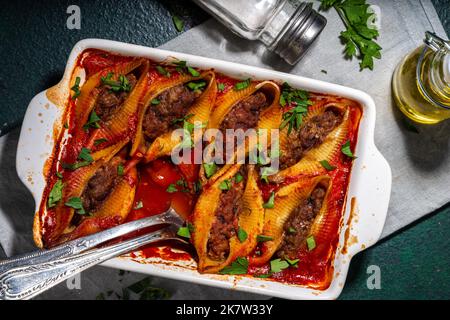 Hausgemachte Pasta-Muscheln, italienische Conchiglioni gefüllt mit Hackfleisch aus Hackfleisch in Tomatensauce mit Kräutern Stockfoto