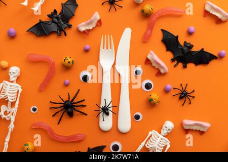 Halloween Dinner Party Hintergrund. Besteck mit halloween-Dekorationen und Süßigkeiten Stockfoto