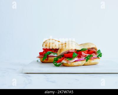 Leckeres Sandwich mit Schinken, Mozarella und frischem Gemüse. Einfaches Mittagskonzept. Speicherplatz kopieren Stockfoto