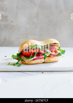 Leckeres Sandwich mit Schinken, Mozarella und frischem Gemüse. Einfaches Mittagskonzept. Speicherplatz kopieren Stockfoto