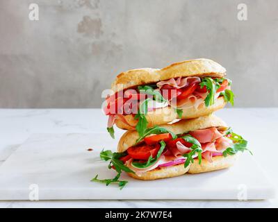 Leckeres Sandwich mit Schinken, Mozarella und frischem Gemüse. Einfaches Mittagskonzept. Speicherplatz kopieren Stockfoto