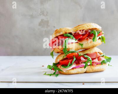 Leckeres Sandwich mit Schinken, Mozarella und frischem Gemüse. Einfaches Mittagskonzept. Speicherplatz kopieren Stockfoto