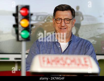 Viersen, Deutschland. 19. Oktober 2022. Fahrlehrer Horst Wintgen sitzt im Übungsraum seiner Fahrschule mit einer Ampel und einem Schild der Fahrschule. An den Nordrhein-westfälischen Fahrschulen herrscht Prüfungschaos. TÜV-Rheinland führt Samstagsprüfungen ein, um lange Wartezeiten zu reduzieren. Quelle: Roland Weihrauch/dpa/Alamy Live News Stockfoto