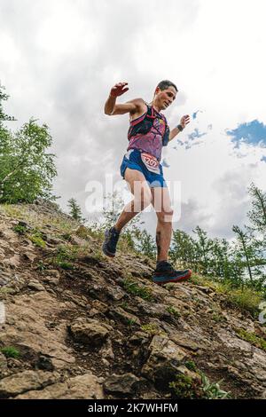 Bannoe, Russland - 31. Juli 2022: Mann-Läufer laufen steilen Bergabstieg im MMK Wild Trail Stockfoto