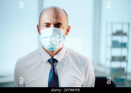 Wissenschaftler in einer Schutzmaske auf dem Hintergrund eines medizinischen Labors. Stockfoto