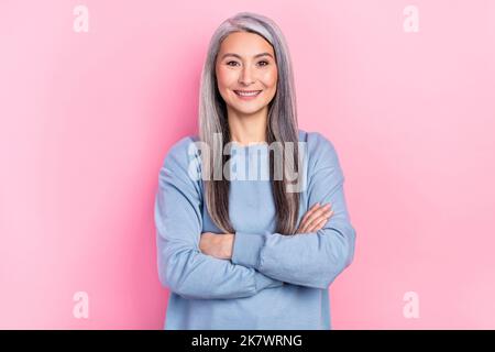 Foto von süßen hübschen pensionierten Frau blauen Pullover lächelnde Arme überquerte isoliert rosa Hintergrund Stockfoto