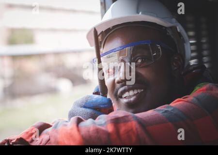 Afrikanischer Mann Ingenieur Controller Überprüfung, arbeiten mit Funkübertragung oder Walkie-Talkie in Raumsystem in der Industrie Stockfoto