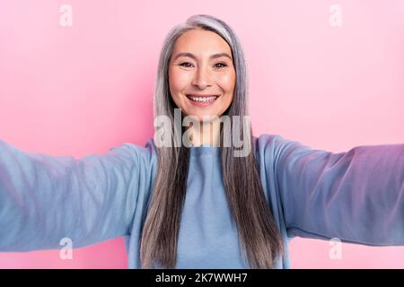 Foto von funky charmante Dame Rentner gekleidet blauen Pullover Aufnahme selbst Video isoliert rosa Farbe Hintergrund Stockfoto