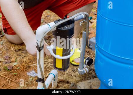 Wartung durch professionelle Arbeiter Austausch von austauschbaren Filtern für die Reinigung von Wasser im Freien in der Nähe von zu Hause Stockfoto