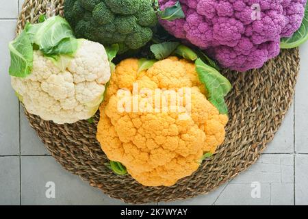 Colorfu-Blumenkohl. Verschiedene Art von Blumenkohl auf Steinfliesen grauen Beton Hintergrund. Violette, gelbe, weiße und grüne Farbkabbage. Brokkoli und Stockfoto