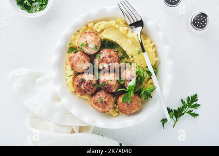 Schwedische Fleischbällchen in Sahnesauce, Kartoffeln und Preiselbeersoße in einer Schüssel auf Schiefer-, Stein- oder Betonböden. Schwedische Küche. Köstliche cremige ma Stockfoto