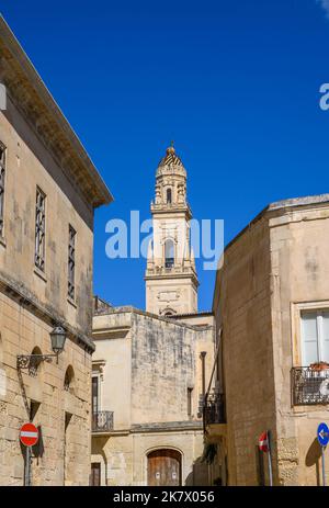 Der Glockenturm der Kathedrale von Lecce, sichtbar hinter und zwischen den Steingebäuden der Altstadt. Apulien (Apulien), Italien. Stockfoto