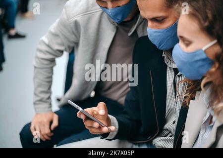 Gruppe junger Menschen, die auf den Smartphone-Bildschirm schauen. Stockfoto
