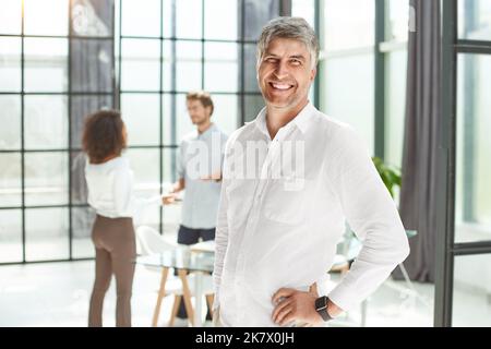 Selbstbewusster Geschäftsmann, der im Büro steht. Stockfoto