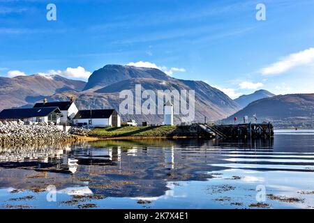 Corpach und Ben Nevis Berg die Gebäude des Caledonian Canal und der kleine weiße Leuchtturm spiegeln sich im Wasser des Loch Eil wider Stockfoto