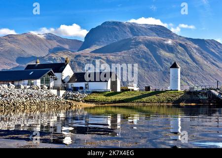 Corpach und Ben Nevis die Gebäude des Kaledonischen Kanals und der kleine weiße Leuchtturm spiegeln sich im Wasser des Loch Eil wider Stockfoto