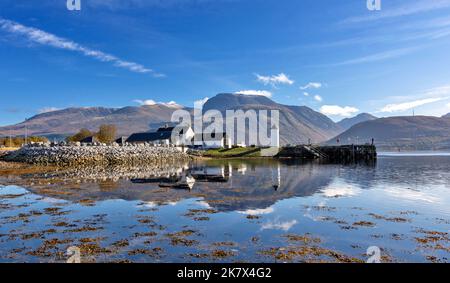 Corpach und Ben Nevis die Gebäude des Kaledonischen Kanals mit dem kleinen weißen Leuchtturm, der sich im Wasser des Loch Eil widerspiegelt Stockfoto