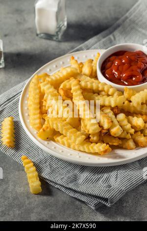 Hausgemachte Crinkle Cut Pommes mit Ketchup Stockfoto