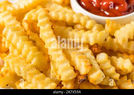 Hausgemachte Crinkle Cut Pommes mit Ketchup Stockfoto