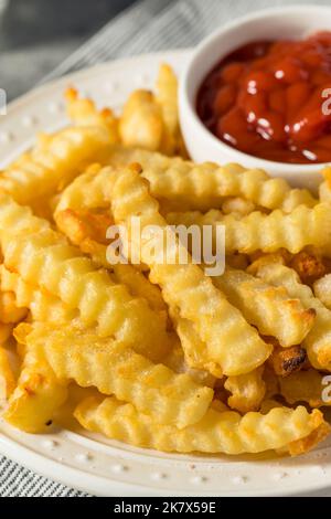 Hausgemachte Crinkle Cut Pommes mit Ketchup Stockfoto