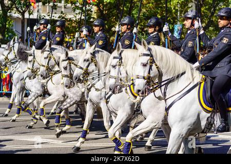 Madrid, Spanien, 12. Oktober 2022: Eine Gruppe von Militärreitern, die auf dem Pferderücken in einer Reihe mit schönen weißen Pferden bestiegen sind. Stockfoto