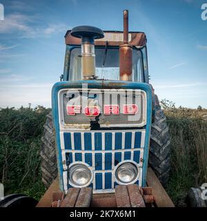 Alter Ford Traktor auf einem Feld, Vorderansicht.