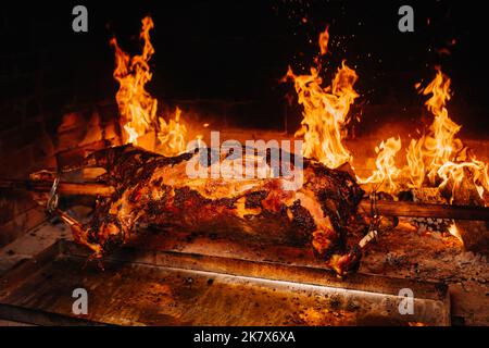 Das Lamm wird komplett auf einem Spieß auf dem Feuer gekocht. Kochen Stockfoto