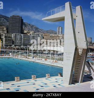 1964, historisch, Blick aus dieser Zeit auf den Staat Nautique Rainier III, ein Freibad mitten im Hafen von Port Hercules in Monaco, mit einer Haupttauchplattform und kleineren, steinernen Plattformen am Pool. Der Meerwasserpool in olympischer Größe wurde im August 1961 offiziell eröffnet. Stockfoto