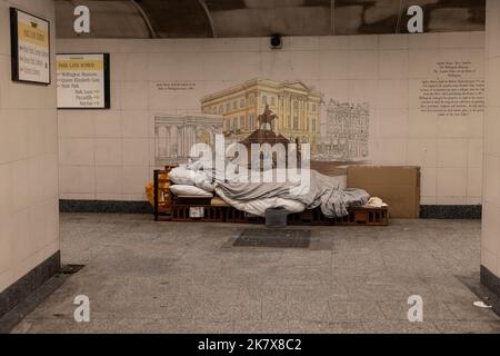 Obdachlose schlafen in einem temporären Bett, das auf einer Pappbasis in einer unterirdischen U-Bahn, Hyde Park, London, England, Großbritannien, sitzt Stockfoto