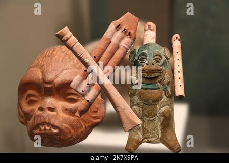 Die Brüllaffe Gottheit der Maya Beschützer der Künste wie Musik zusammen mit einigen typischen Maya-Musikinstrumenten. Stockfoto