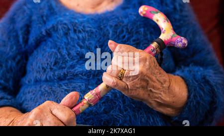 Nahaufnahme der Hände einer älteren Frau, die einen Gehstock hält. Detail der alten kaukasischen Oma Hand halten Griff von Stock. Konzept für ältere Menschen. Stockfoto