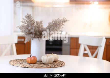 Moderne Küche mit herbstlichen saisonalen Dekorationen mit herbsttrockenen Blumen und Kürbissen. Home Küche Interieur für Thanksgiving Tag dekoriert. Nahaufnahme. Stockfoto