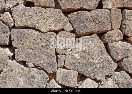 Steinmauer aus vulkanischem Gestein auf Lanzarote. Nahaufnahme der Trockensteinmauer aus vulkanischem Gestein Stockfoto