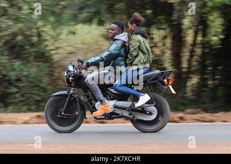 Ein Sozius, der auf Motorradtaxis fährt, bekannt als Boda Boda, in Ostafrika. Boda bodas sind ein wichtiger Teil des Verkehrsnetzes und werden genutzt Stockfoto