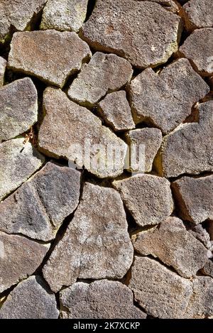 Steinmauer aus vulkanischem Gestein auf Lanzarote. Nahaufnahme der Trockensteinmauer aus vulkanischem Gestein Stockfoto