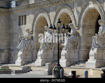Drei gewölbte Eingänge mit Statuen und einer dekorativen Straßenlampe Stockfoto